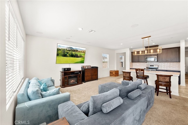 27108 Oncore Dr, Menifee, CA 92585 - living area with light carpet, recessed lighting, and a glass covered fireplace