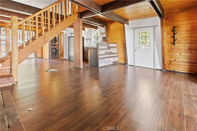 2068 Slippery Elm Rd, Wrightwood, CA 92397 - unfurnished living room featuring beamed ceiling, hardwood / wood-style flooring, wood walls, stairway, and stacked washing machine and dryer