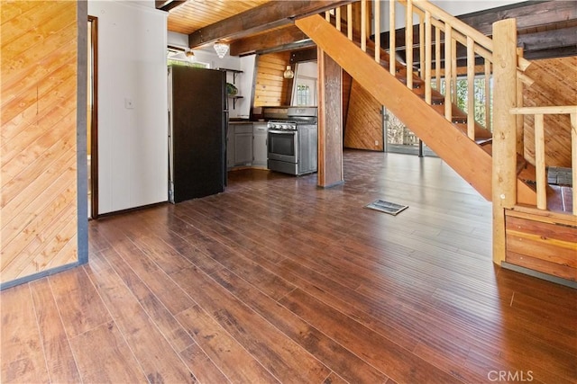 2068 Slippery Elm Rd, Wrightwood, CA 92397 - kitchen with stainless steel gas stove, freestanding refrigerator, dark countertops, dark wood-type flooring, and wooden walls