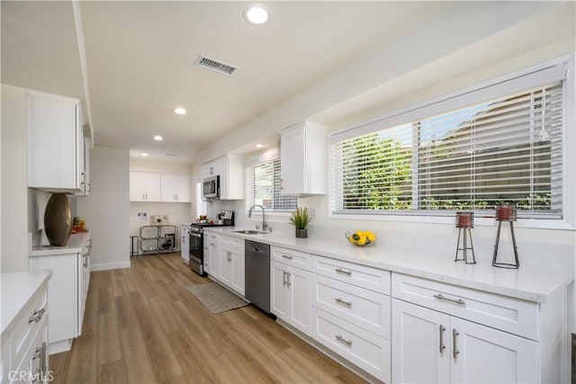 1610 Wandering Dr, Monterey Park, CA 91754 - kitchen with stainless steel appliances, recessed lighting, white cabinetry, and light wood-type flooring