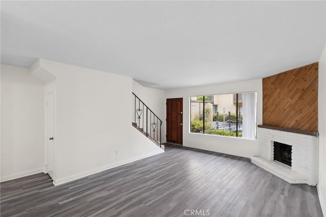 10249 Black Mountain Rd Unit Q3, San Diego, CA 92126 - unfurnished living room with stairs, dark wood-style flooring, and a brick fireplace