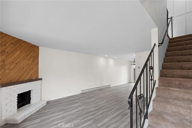 10249 Black Mountain Rd Unit Q3, San Diego, CA 92126 - stairs featuring a baseboard radiator, wood finished floors, wood walls, recessed lighting, and a brick fireplace