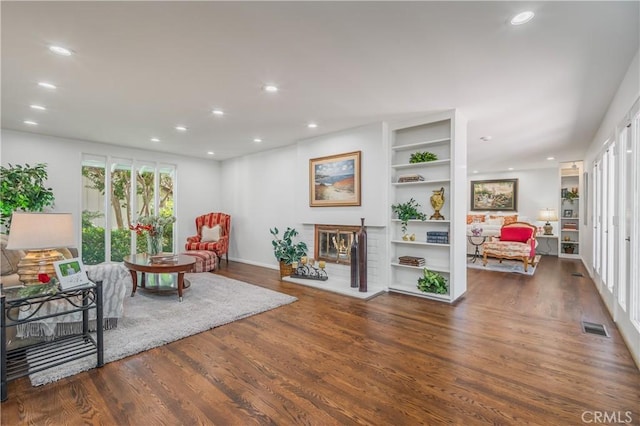 3131 E Cortez St, West Covina, CA 91791 - living room featuring wood finished floors, recessed lighting, built in shelves, and a brick fireplace