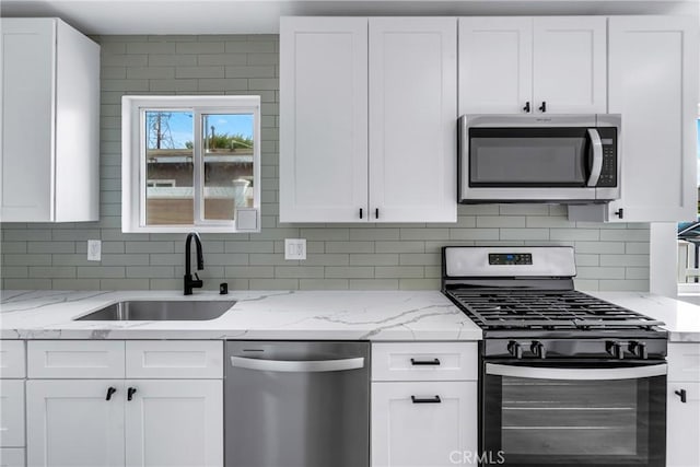 4713 Calada Ave, Pico Rivera, CA 90660 - kitchen with appliances with stainless steel finishes, white cabinets, tasteful backsplash, and light stone countertops