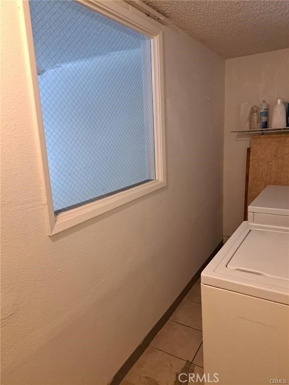 15205 S Budlong Ave Unit 9, Gardena, CA 90247 - washroom with washer and dryer, light tile patterned flooring, and a textured ceiling