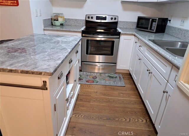 15205 S Budlong Ave Unit 9, Gardena, CA 90247 - kitchen featuring stainless steel appliances, white cabinetry, dark wood-type flooring, and light stone countertops