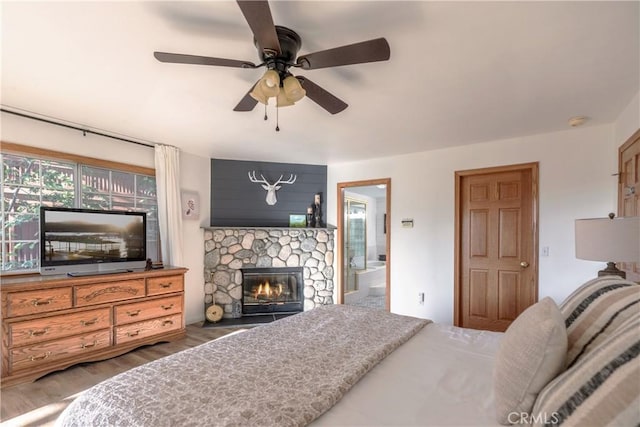 1244 St Anton Dr, Lake Arrowhead, CA 92352 - bedroom featuring a fireplace, wood finished floors, connected bathroom, and ceiling fan