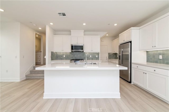 474 Lobata, Irvine, CA 92618 - kitchen with stainless steel appliances, light countertops, light wood-style floors, decorative backsplash, and recessed lighting