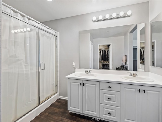 11760 Espola Pl, Victorville, CA 92392 - bathroom with a spacious closet, a shower stall, double vanity, and wood finished floors