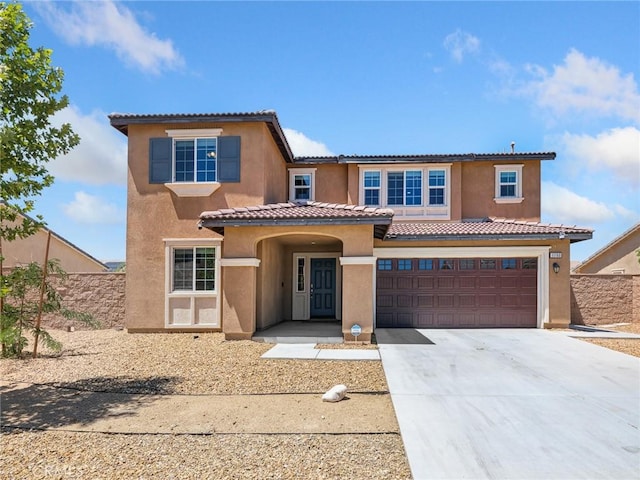 11760 Espola Pl, Victorville, CA 92392 - mediterranean / spanish house featuring driveway, stucco siding, a tile roof, and an attached garage