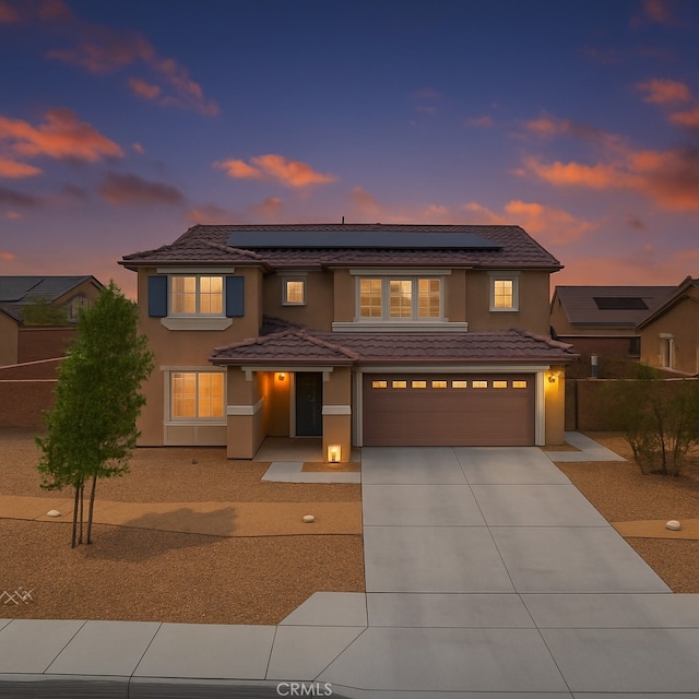 11760 Espola Pl, Victorville, CA 92392 - view of front facade with concrete driveway, a garage, stucco siding, and roof mounted solar panels