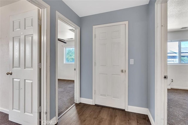 2246 Beachwood Dr, Merced, CA 95348 - hallway featuring dark colored carpet, plenty of natural light, and dark wood-type flooring
