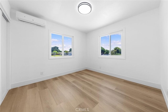 1851 S San Antonio Ave, Pomona, CA 91766 - unfurnished bedroom with an AC wall unit, multiple windows, light wood finished floors, and a closet