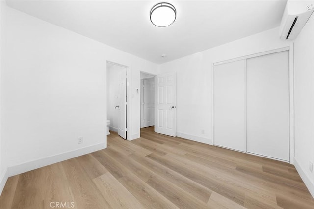 1851 S San Antonio Ave, Pomona, CA 91766 - unfurnished bedroom featuring a wall unit AC, wood finished floors, and a closet