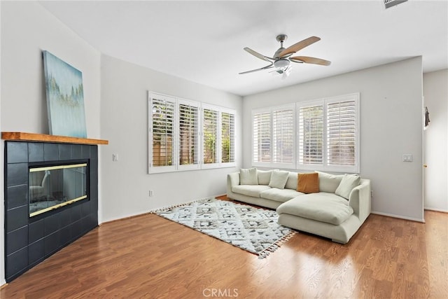 27664 Cordovan Dr, Canyon Country, CA 91351 - living room featuring a ceiling fan, wood finished floors, and a tile fireplace