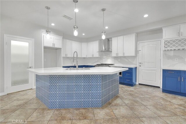 12790 Golden Leaf Dr, Rancho Cucamonga, CA 91739 - kitchen with blue cabinetry, wall chimney range hood, white cabinets, and recessed lighting
