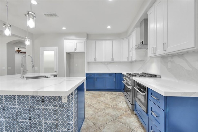 12790 Golden Leaf Dr, Rancho Cucamonga, CA 91739 - kitchen with blue cabinets, wall chimney exhaust hood, white cabinetry, and recessed lighting