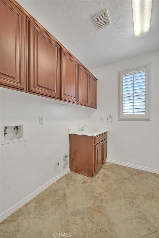 12790 Golden Leaf Dr, Rancho Cucamonga, CA 91739 - laundry room featuring gas dryer hookup, washer hookup, cabinet space, and a textured ceiling