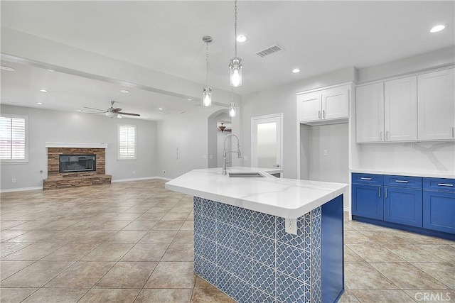12790 Golden Leaf Dr, Rancho Cucamonga, CA 91739 - kitchen featuring blue cabinets, ceiling fan, arched walkways, pendant lighting, and white cabinetry