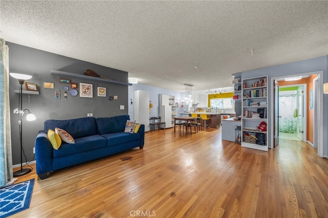 5110 E Atherton St Unit 57, Long Beach, CA 90815 - living room with a textured ceiling, light wood-style flooring, and a chandelier
