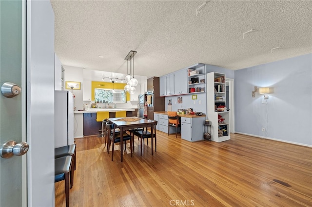 5110 E Atherton St Unit 57, Long Beach, CA 90815 - dining space featuring a textured ceiling, light wood-style floors, and a desk