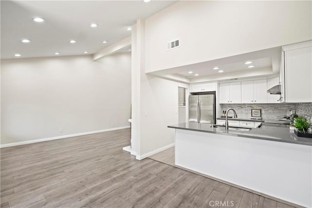 4366 Fairview Ave Unit 6, Arcadia, CA 91007 - kitchen with freestanding refrigerator, light wood-style flooring, dark countertops, decorative backsplash, and white cabinets
