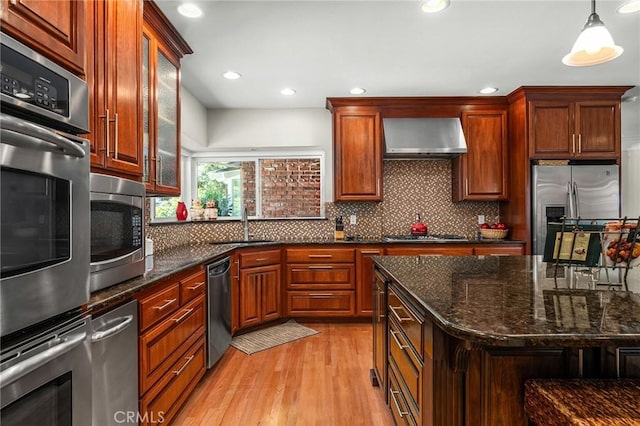 45 Covell Park Ave, Chico, CA 95926 - kitchen featuring wall chimney range hood, stainless steel appliances, light wood-type flooring, tasteful backsplash, and pendant lighting
