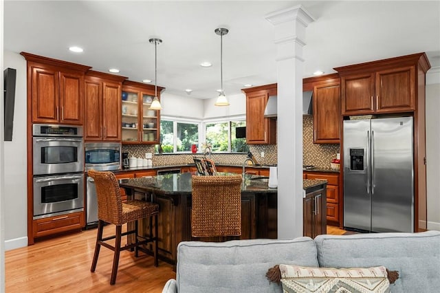 45 Covell Park Ave, Chico, CA 95926 - kitchen featuring appliances with stainless steel finishes, decorative backsplash, wall chimney range hood, light wood-type flooring, and glass insert cabinets