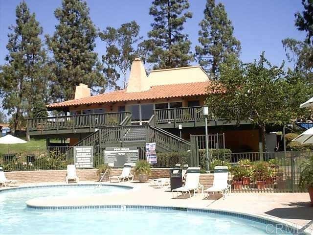 17189 W Bernardo Dr W Unit 103, San Diego, CA 92127 - back of house with stairs, a community pool, and a chimney