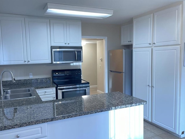 17189 W Bernardo Dr W Unit 103, San Diego, CA 92127 - kitchen with stainless steel appliances, white cabinets, a peninsula, and dark stone counters
