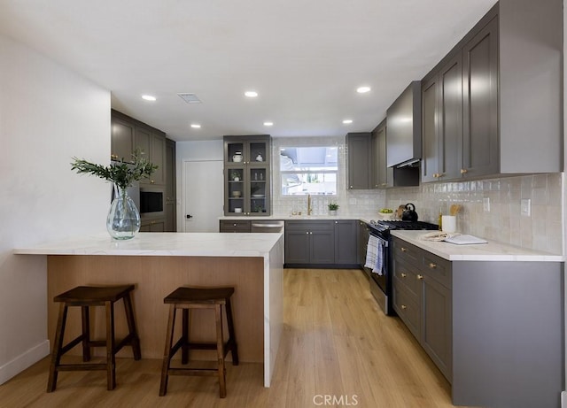 7830 Fairchild Ave, Winnetka, CA 91306 - kitchen with range with gas cooktop, a peninsula, light wood-style floors, dishwasher, and recessed lighting