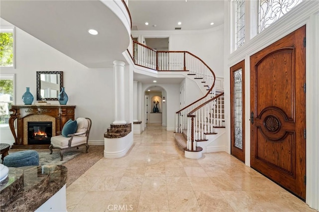 45200 Oak Manor Ct, Temecula, CA 92590 - foyer featuring a high ceiling, stairway, arched walkways, a glass covered fireplace, and recessed lighting