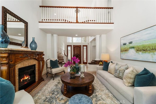 45200 Oak Manor Ct, Temecula, CA 92590 - carpeted living area with a towering ceiling, a glass covered fireplace, stairs, and decorative columns
