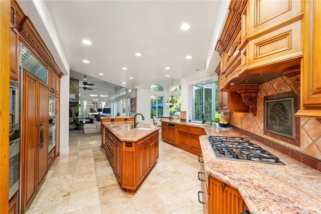 45200 Oak Manor Ct, Temecula, CA 92590 - kitchen with stainless steel appliances, recessed lighting, open floor plan, light stone counters, and backsplash