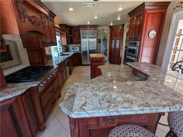 2622 Chauncy Pl, Riverside, CA 92506 - kitchen featuring stainless steel appliances, a center island, decorative backsplash, light tile patterned floors, and recessed lighting