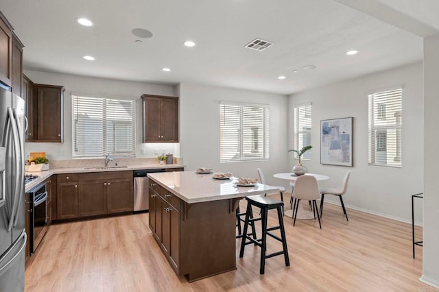 2333 Verano Way, Vista, CA 92081 - kitchen featuring stainless steel appliances, a breakfast bar, a kitchen island, dark brown cabinets, and recessed lighting