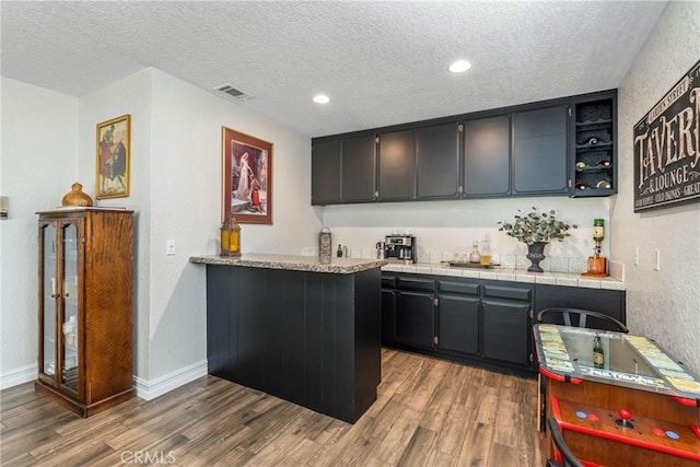 9292 Garden St, Rancho Cucamonga, CA 91701 - indoor wet bar with a textured ceiling, wood finished floors, a textured wall, and recessed lighting