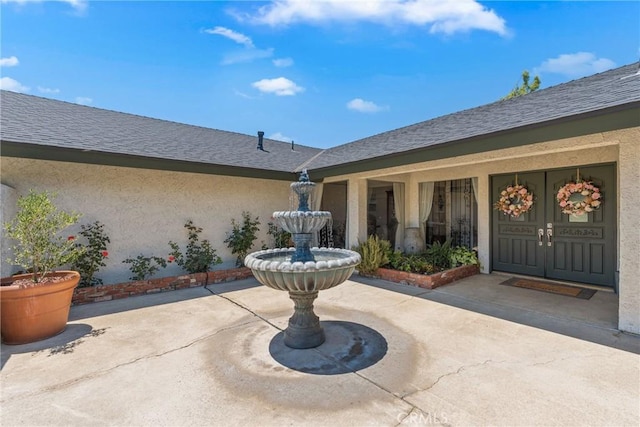 9292 Garden St, Rancho Cucamonga, CA 91701 - view of exterior entry with stucco siding and a shingled roof