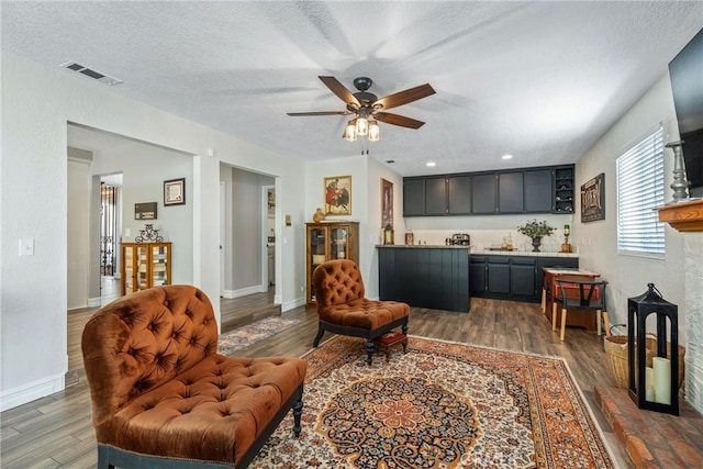 9292 Garden St, Rancho Cucamonga, CA 91701 - living room with wood finished floors, a ceiling fan, bar area, and a textured ceiling
