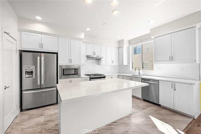 284 Novel, Irvine, CA 92618 - kitchen with stainless steel appliances, light marble finish floors, a kitchen island, under cabinet range hood, and white cabinets