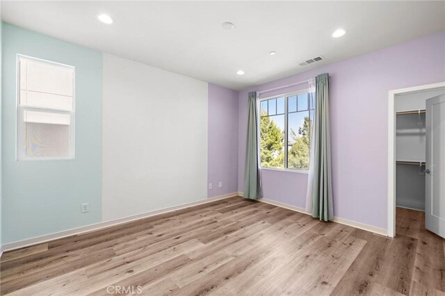 284 Novel, Irvine, CA 92618 - unfurnished bedroom with a walk in closet, wood finished floors, recessed lighting, and a closet
