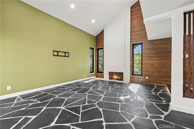 22526 Napa St, West Hills, CA 91304 - unfurnished living room featuring stone floors, high vaulted ceiling, wood walls, recessed lighting, and a brick fireplace