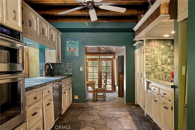 969 Oak Dr, Crestline, CA 92325 - kitchen featuring tile counters, stainless steel appliances, decorative backsplash, a ceiling fan, and beam ceiling
