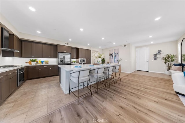 107 Bowery, Irvine, CA 92612 - kitchen with appliances with stainless steel finishes, dark brown cabinetry, light countertops, a center island with sink, and recessed lighting