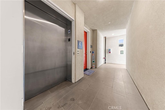 107 Bowery, Irvine, CA 92612 - hall with elevator, a textured wall, and a textured ceiling