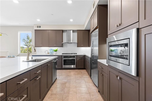 107 Bowery, Irvine, CA 92612 - kitchen featuring stainless steel appliances, wall chimney range hood, light countertops, backsplash, and recessed lighting