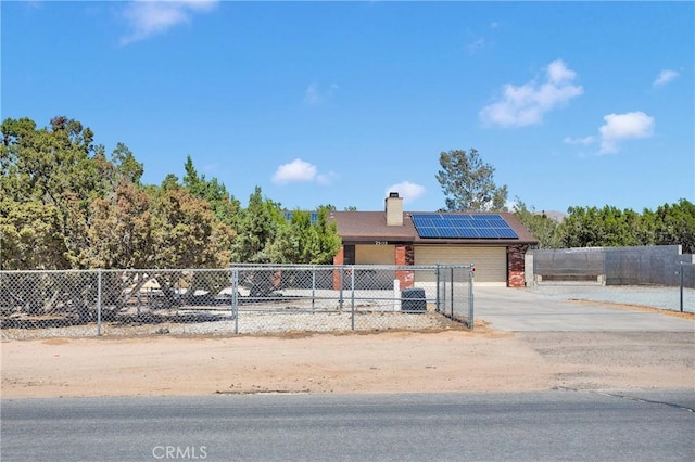7505 Jenkins Ave, Hesperia, CA 92345 - view of front of home with solar panels, a garage, concrete driveway, brick siding, and a chimney