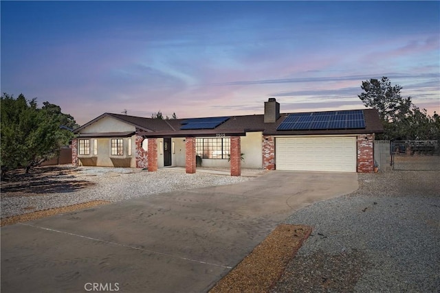 7505 Jenkins Ave, Hesperia, CA 92345 - single story home with concrete driveway, solar panels, an attached garage, a chimney, and brick siding