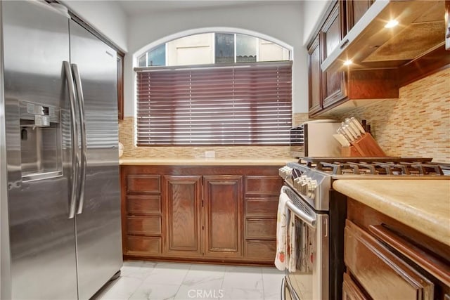 1629 E Palm Ave Unit 3, El Segundo, CA 90245 - kitchen featuring appliances with stainless steel finishes, wall chimney range hood, light marble finish floors, light countertops, and tasteful backsplash