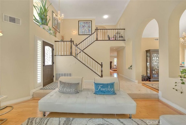 3039 Olympic View Dr, Chino Hills, CA 91709 - entrance foyer featuring arched walkways, wood-type flooring, a high ceiling, stairway, and a chandelier